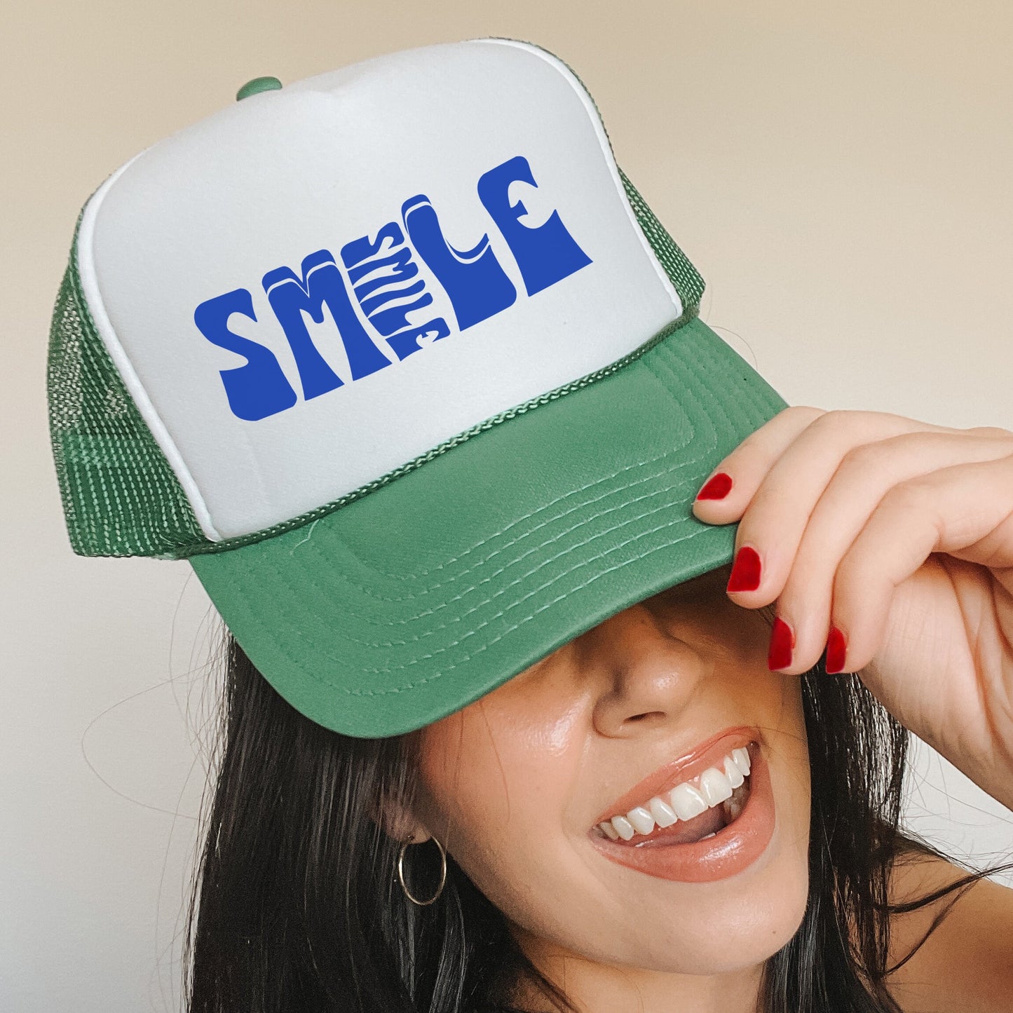 a woman wearing a green and white trucker hat