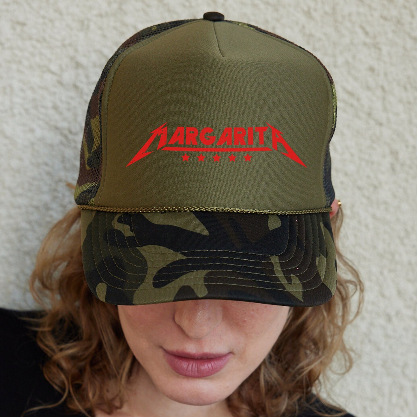 a woman wearing a green and black hat with a metallic metallic logo