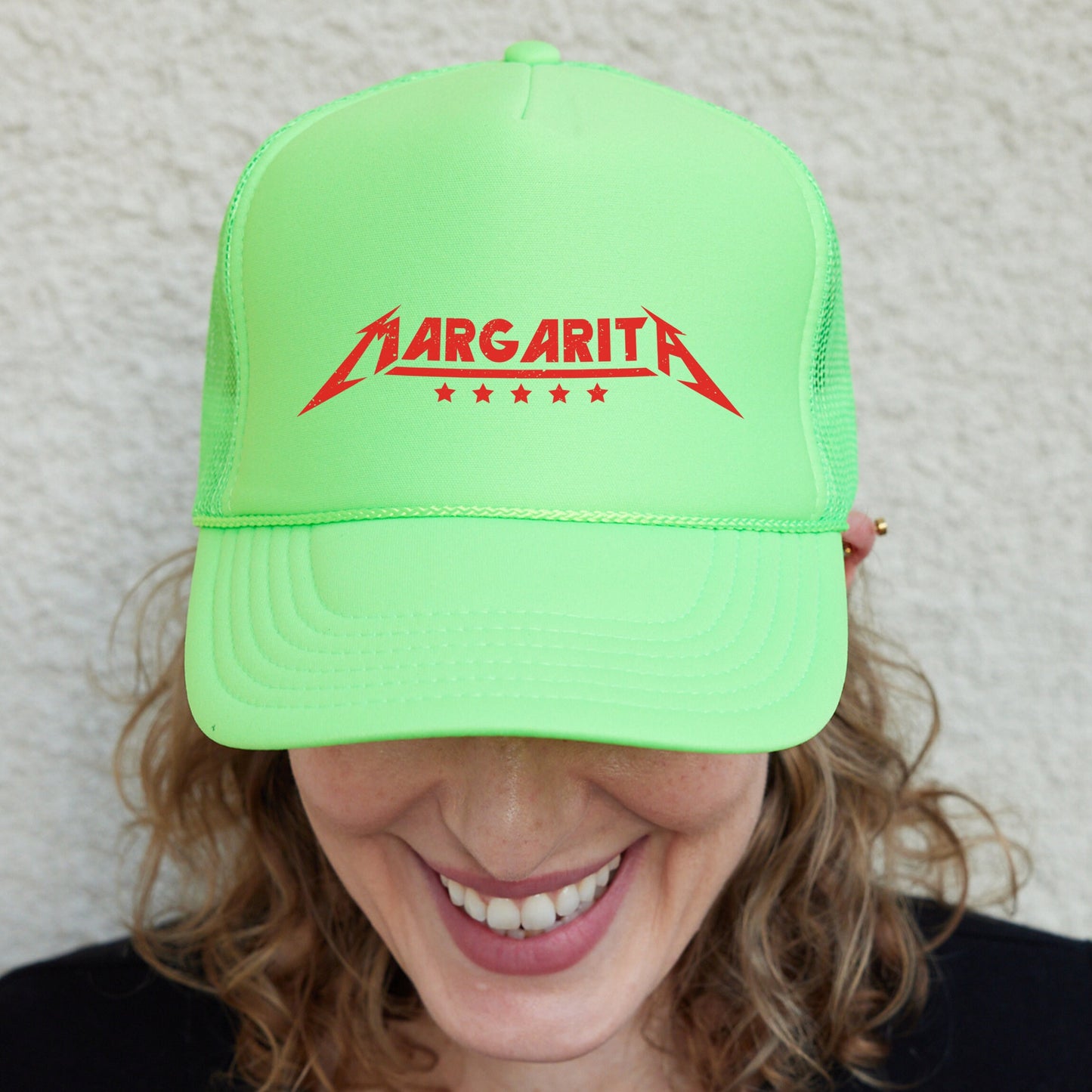 a smiling woman wearing a neon green hat