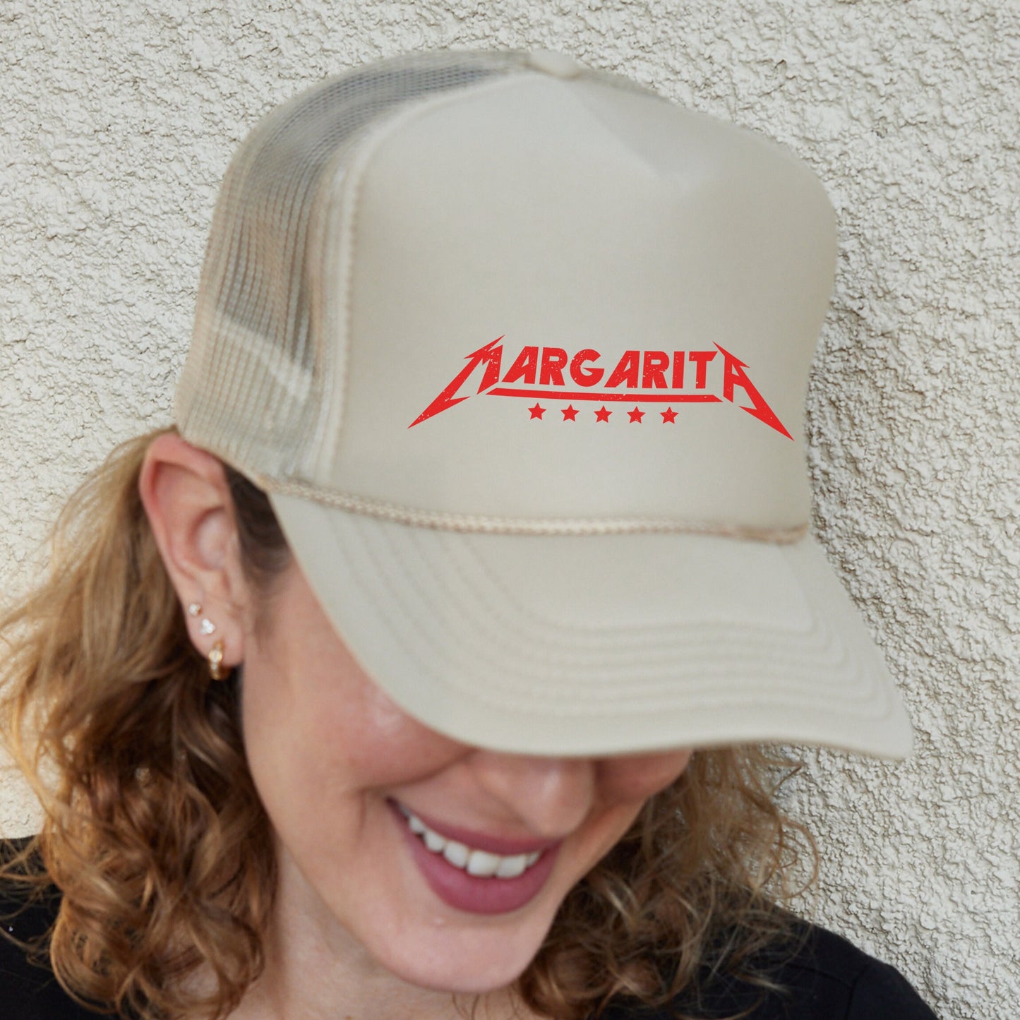 a woman wearing a tan hat with a red logo on it