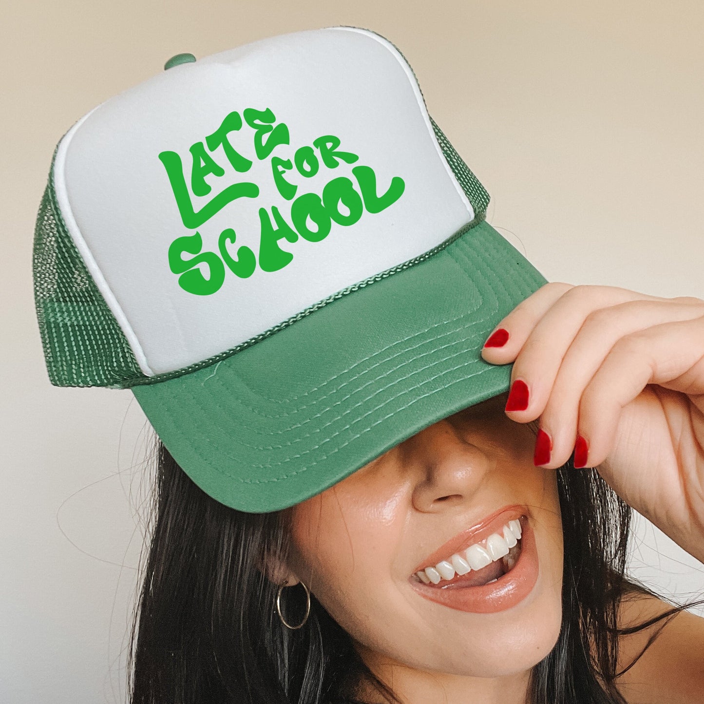 a woman wearing a green and white trucker hat