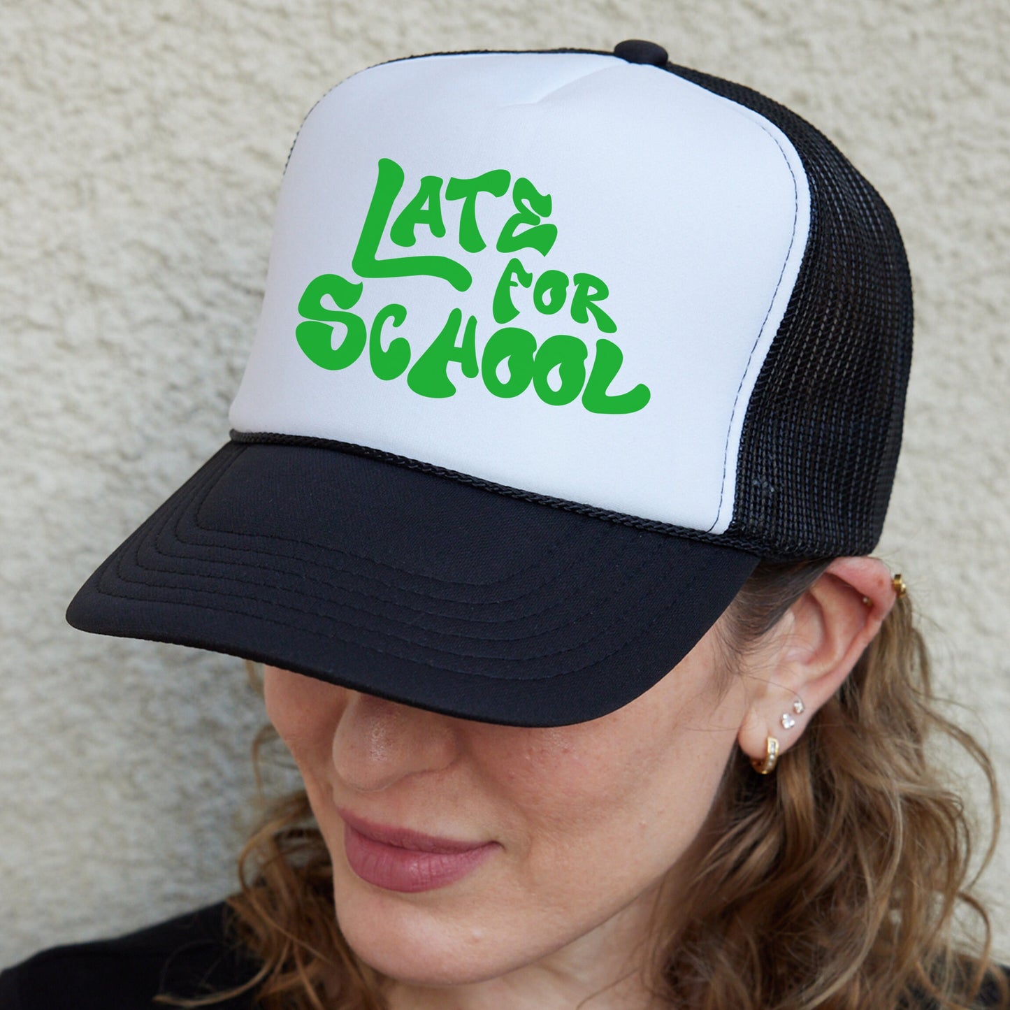 a woman wearing a black and white hat with green letters