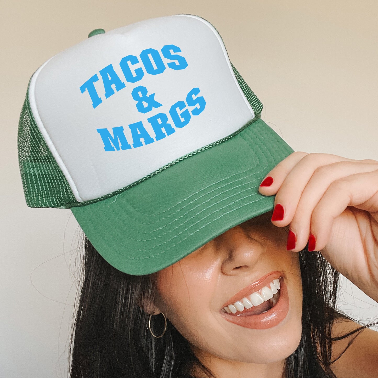 a woman wearing a green and white trucker hat