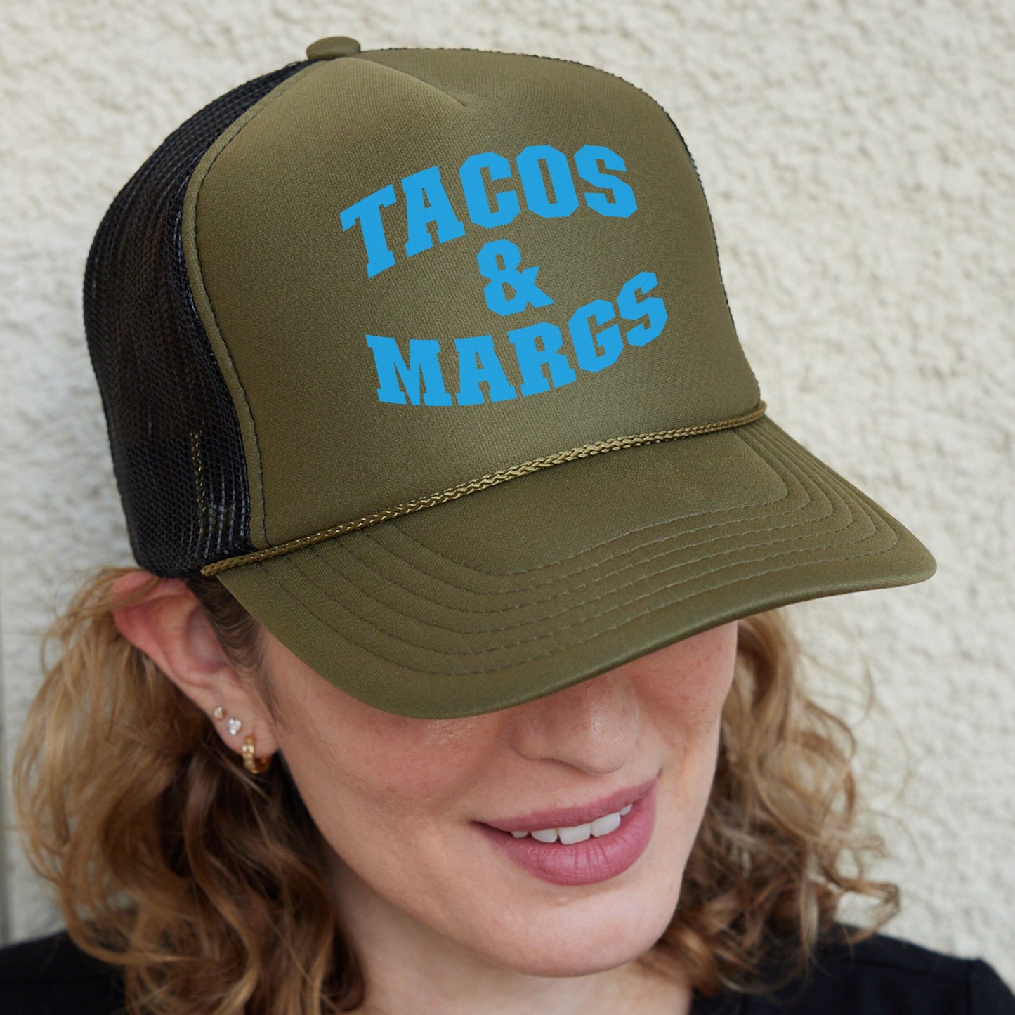 a woman wearing a hat that says tacos and marcs