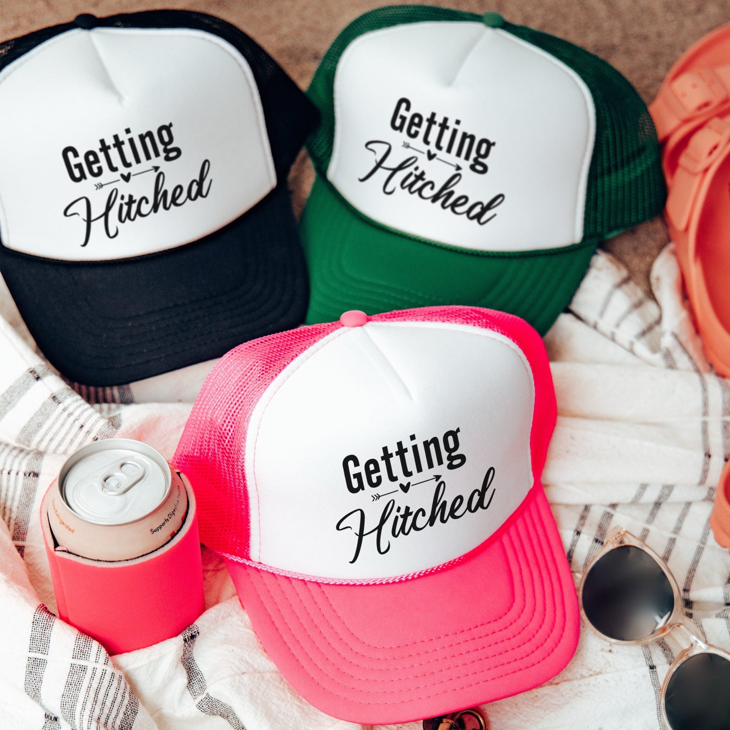 three hats sitting on top of a blanket next to sunglasses