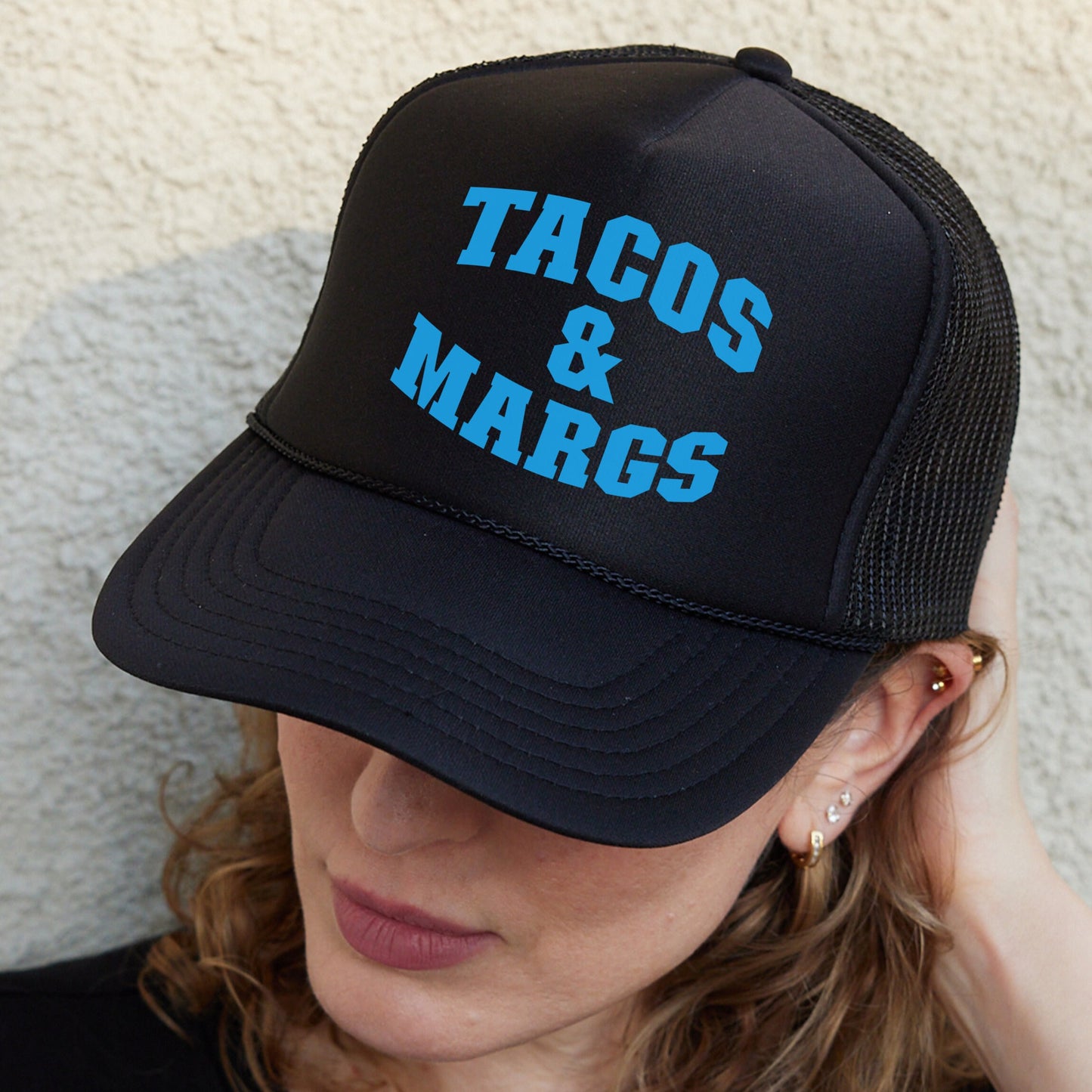 a woman wearing a hat that says tacos and marcs