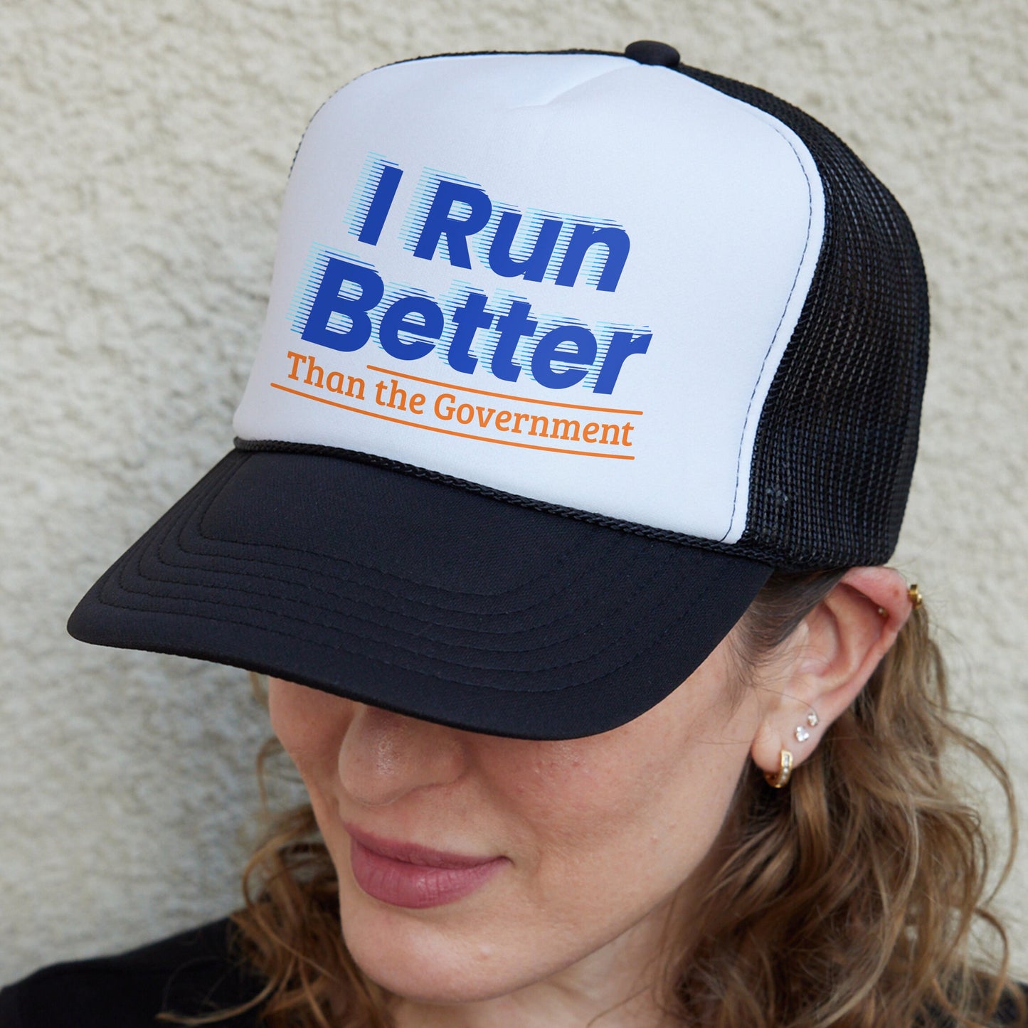 a woman wearing a hat that says i run better than the government