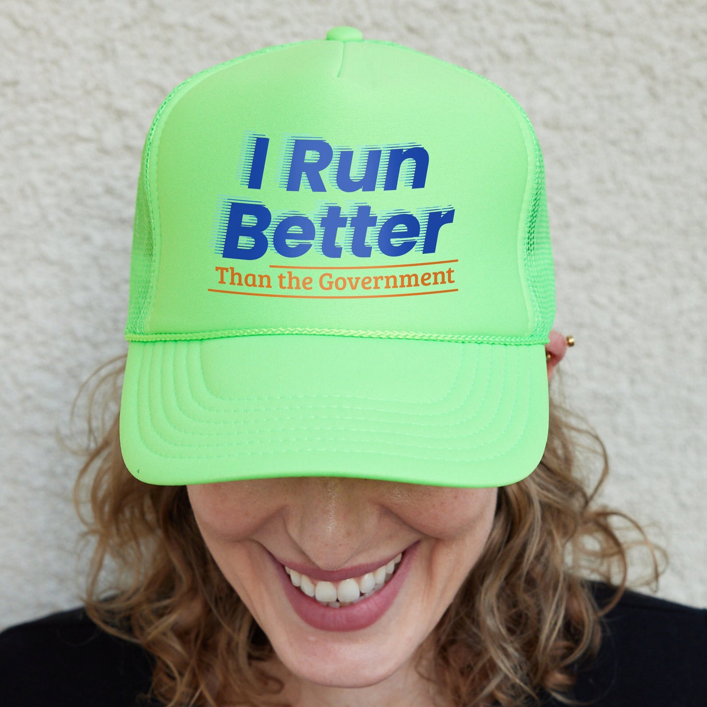 a woman wearing a neon green hat that says i run better than the government