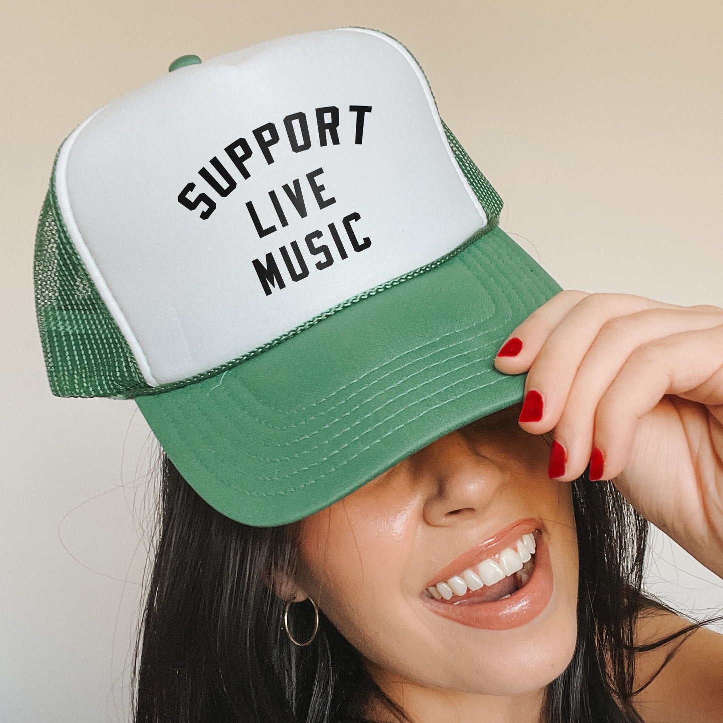 a woman wearing a green and white trucker hat