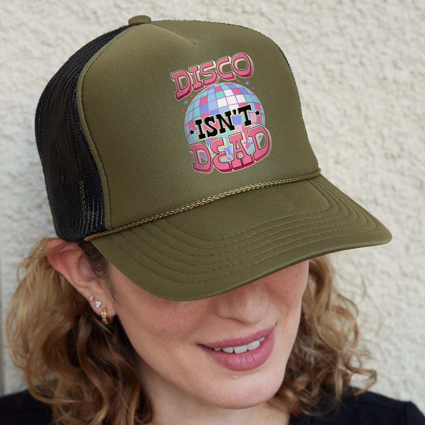 a woman wearing a trucker hat that says disco isn't dead