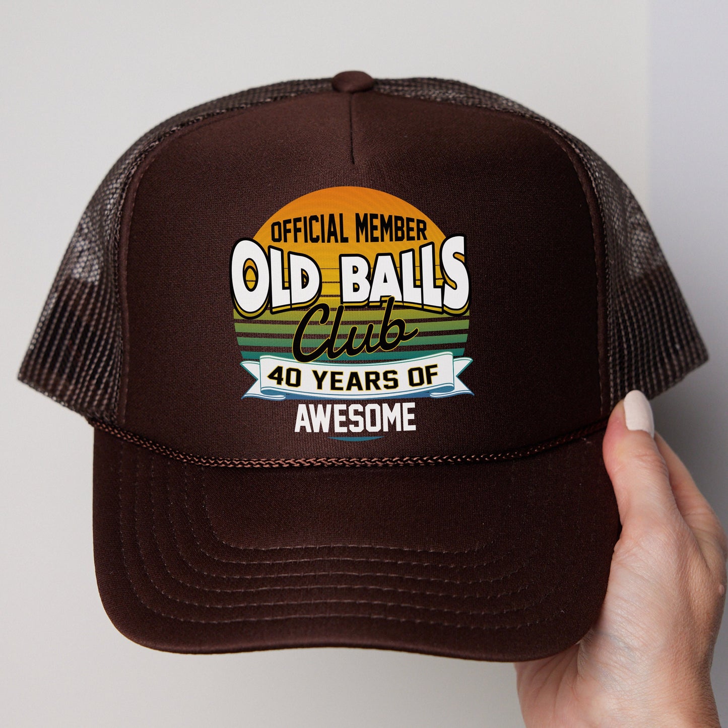 a person holding up a brown trucker hat