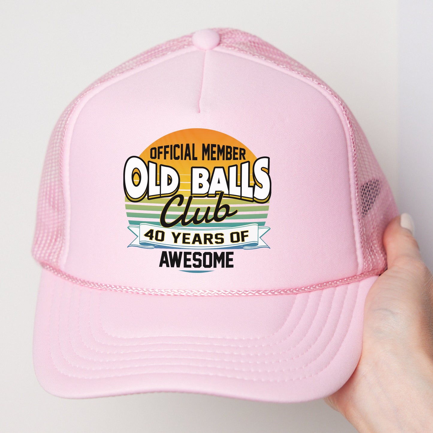a pink trucker hat with an old ball club logo