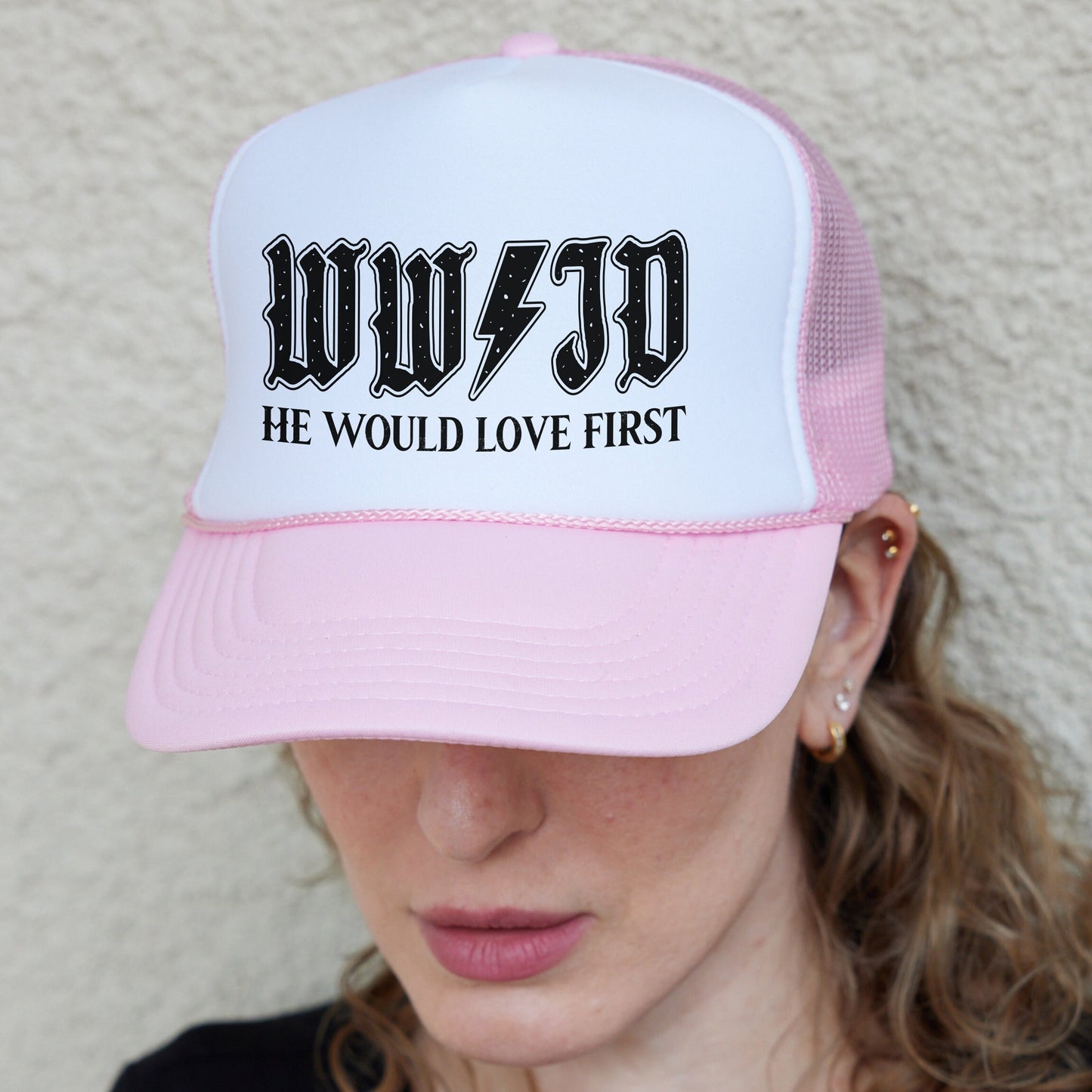 a woman wearing a pink and white trucker hat