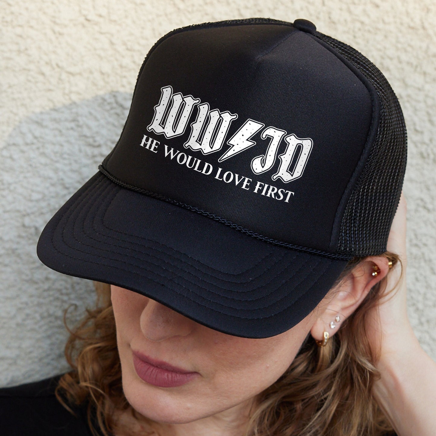a woman wearing a black hat with white lettering