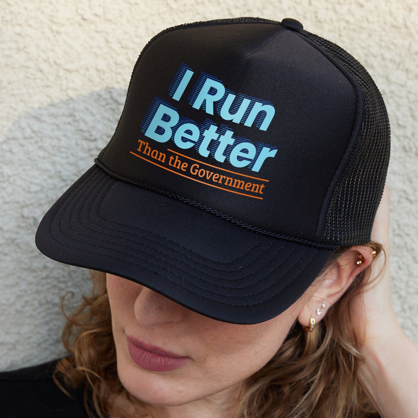 a woman wearing a hat that says i run better than the government