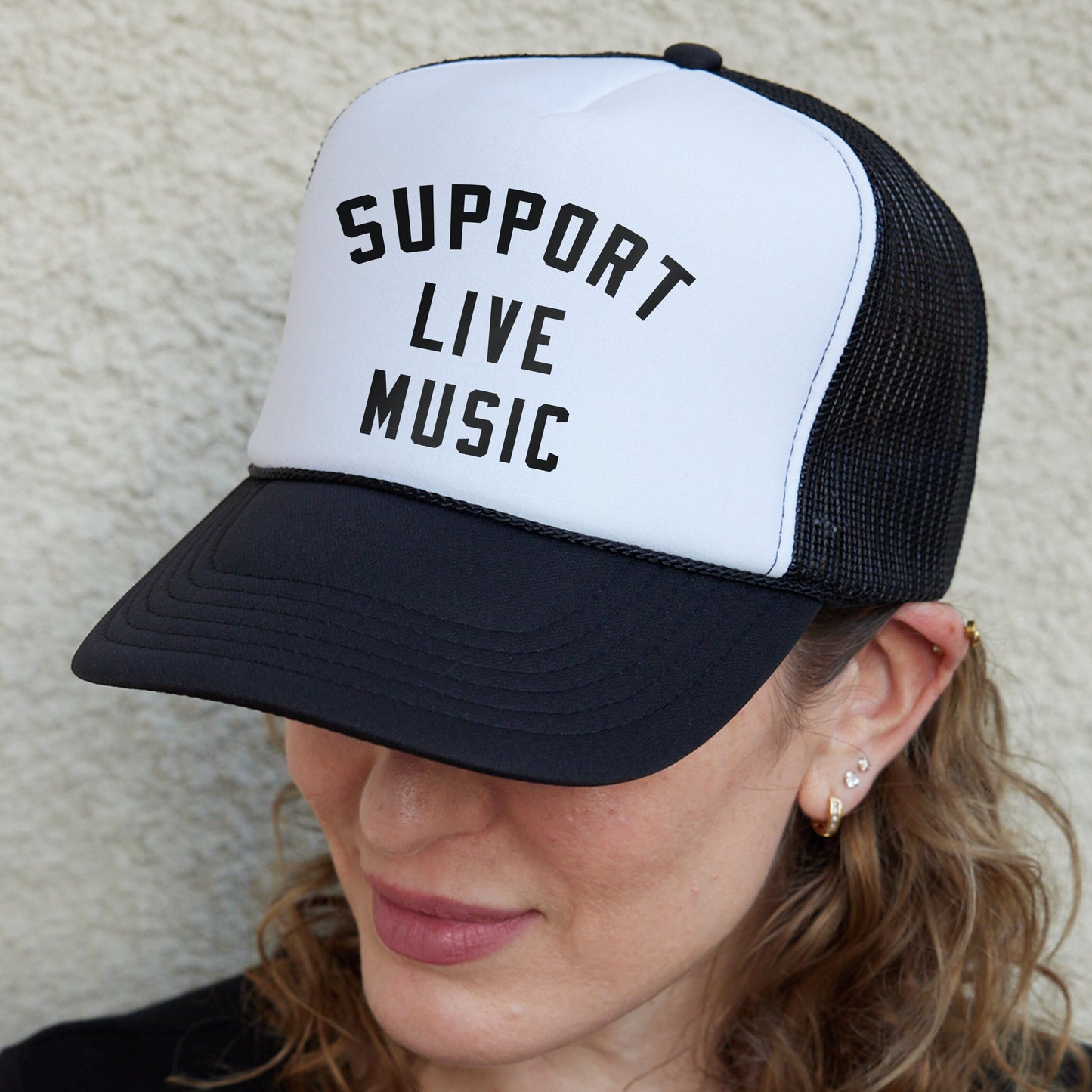 a woman wearing a black and white trucker hat
