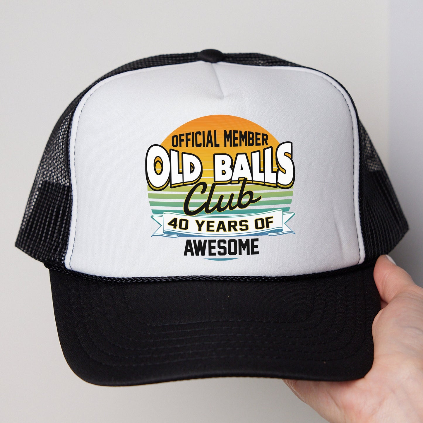 a white and black trucker hat with an old ball club logo