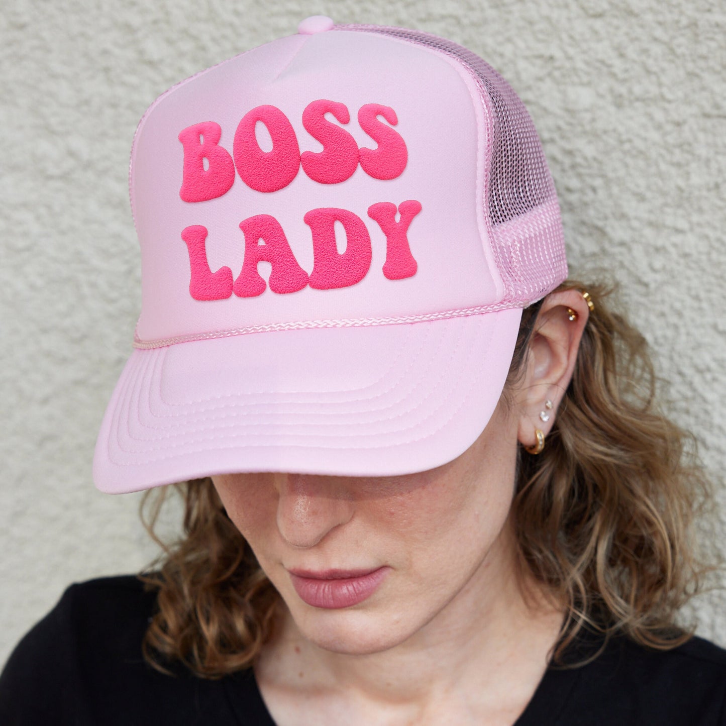 a woman wearing a pink hat that says boss lady