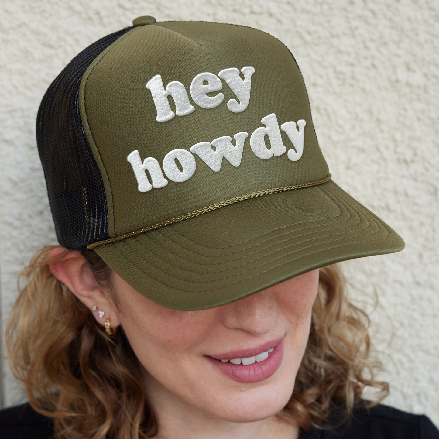 a woman wearing a hat that says hey hovdy