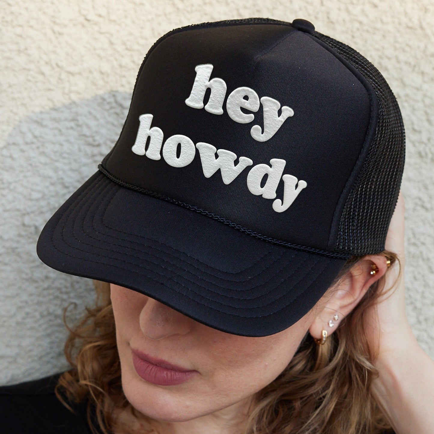 a woman wearing a hat that says hey howdy