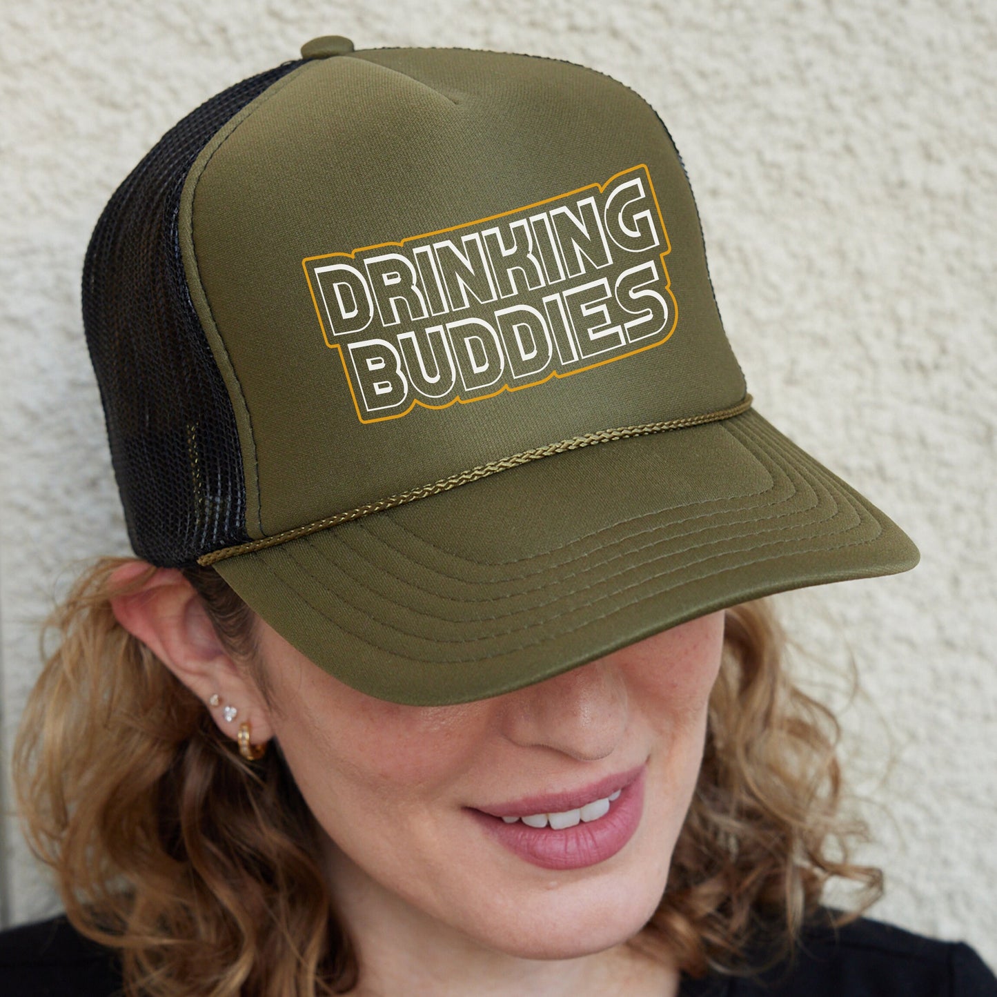 a woman wearing a trucker hat that says drinking buddies