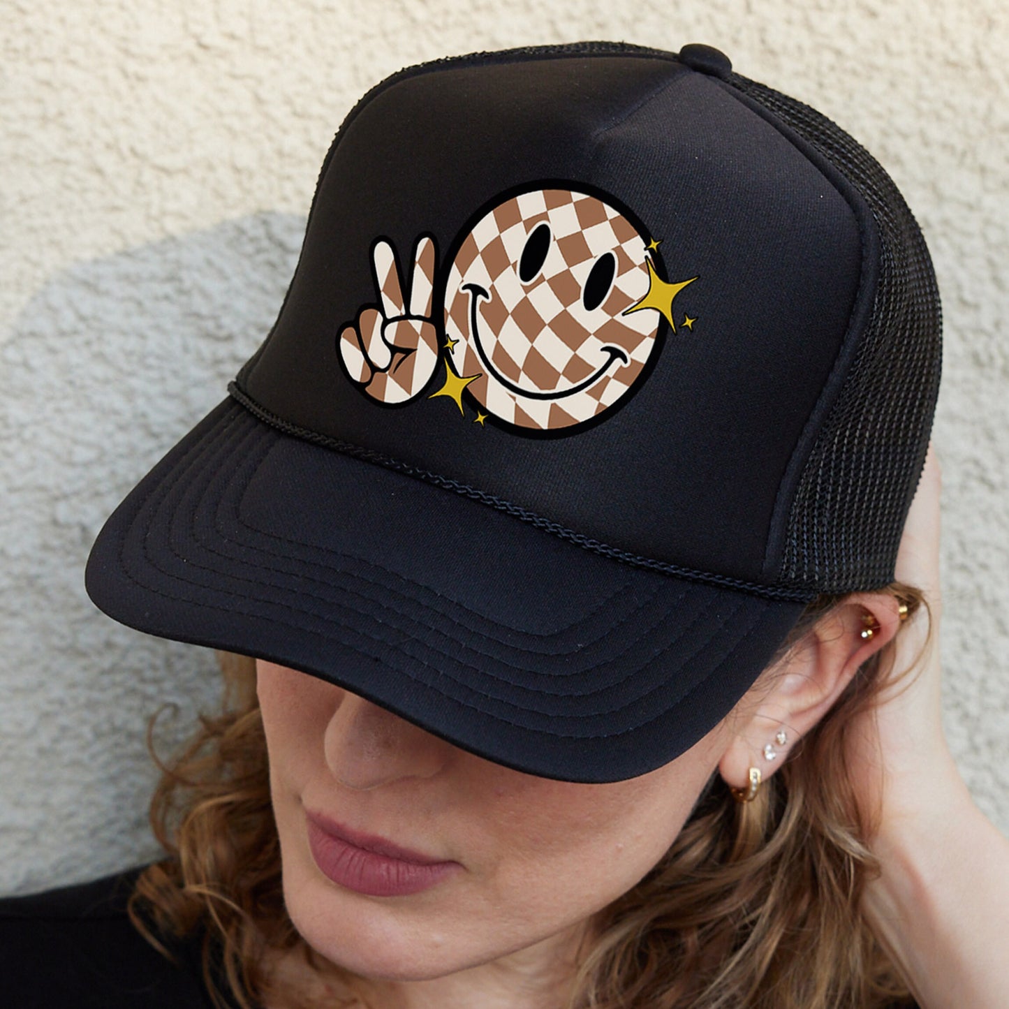 a woman wearing a black hat with a smiley face on it
