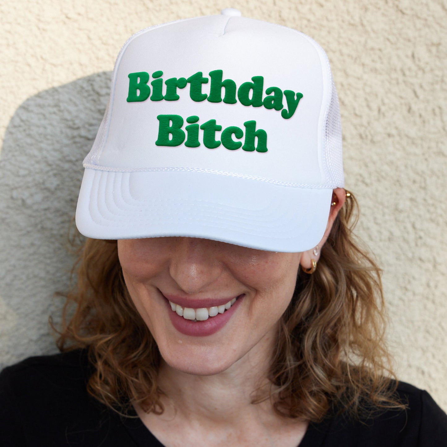 a woman wearing a white hat with the words birthday bitch on it
