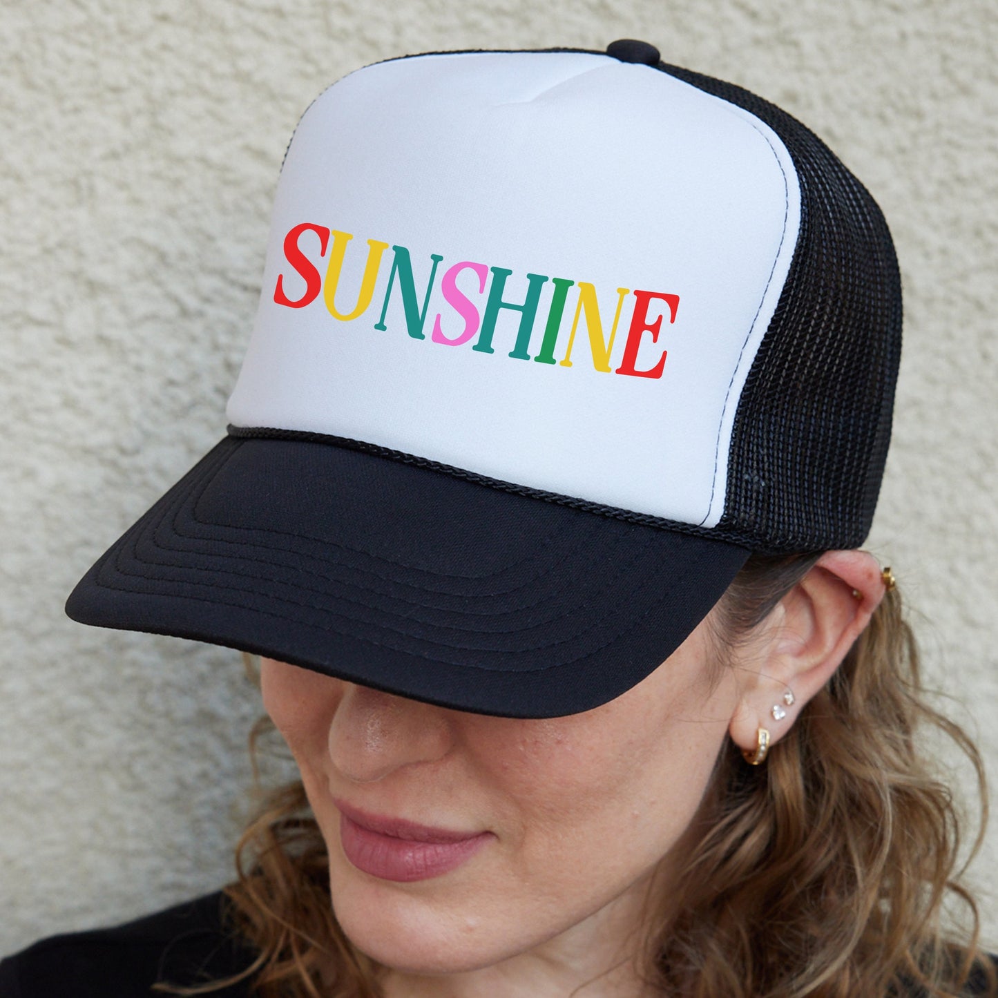 a woman wearing a hat with the word sunshine on it