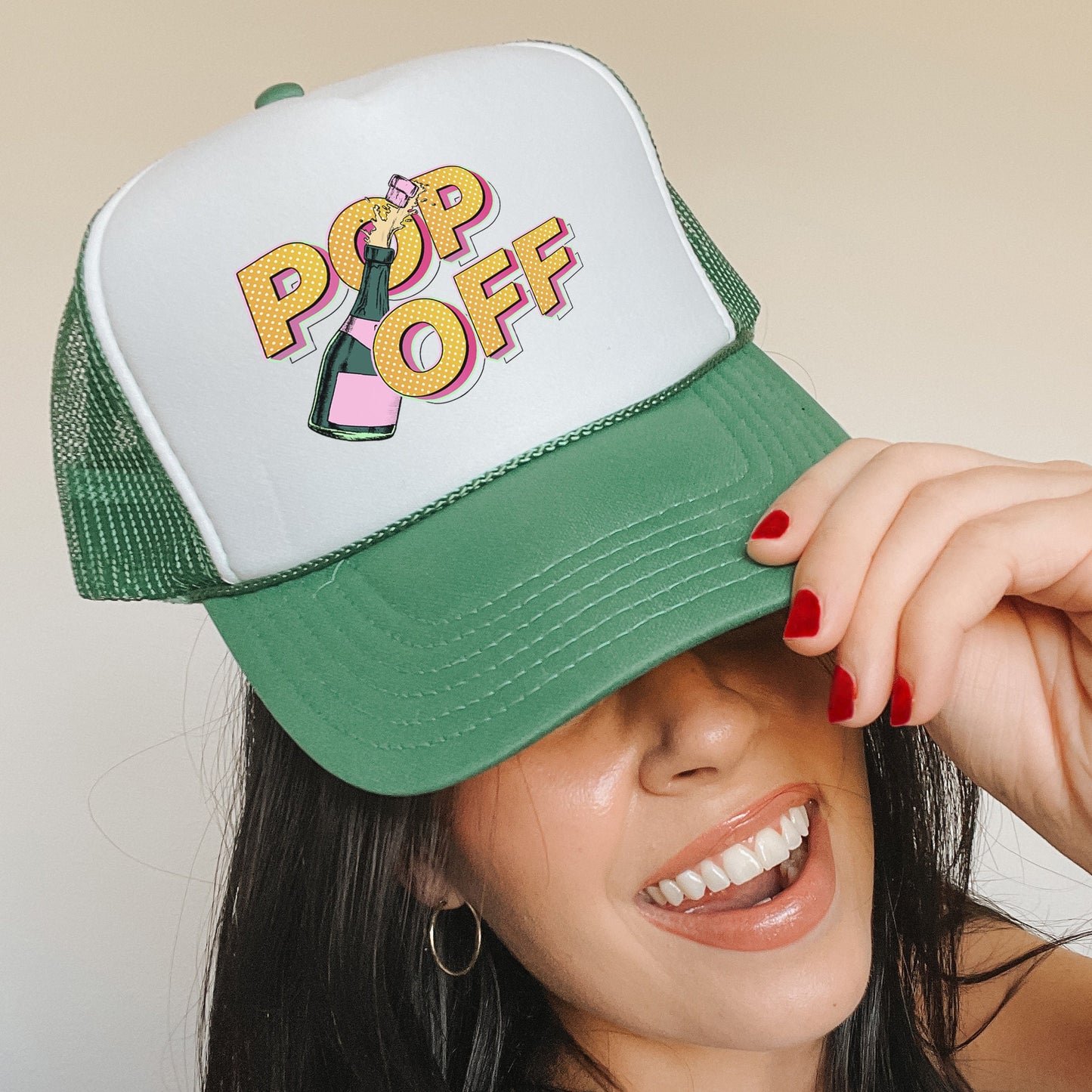 a woman wearing a green and white hat with pop off on it