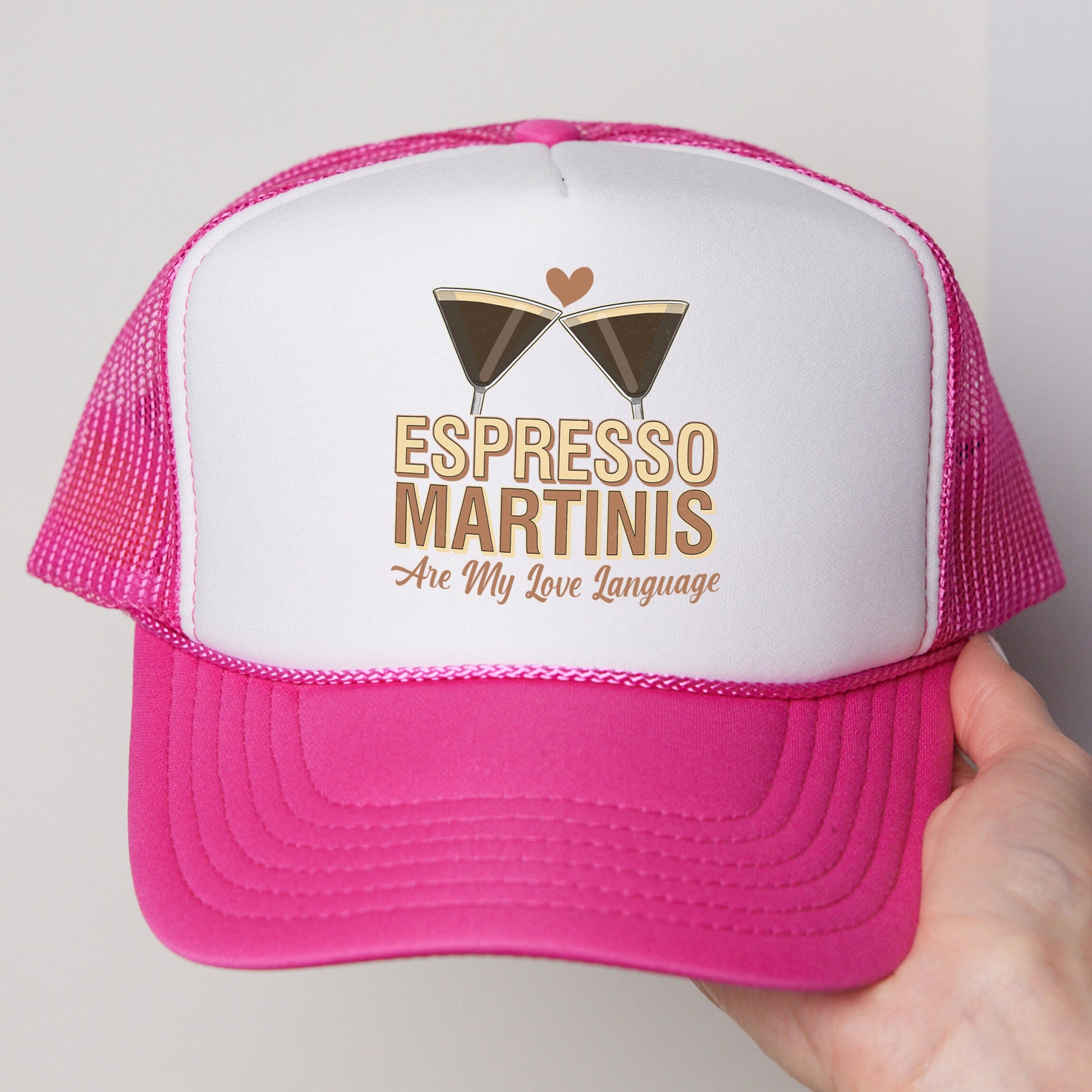 a person holding a pink and white trucker hat