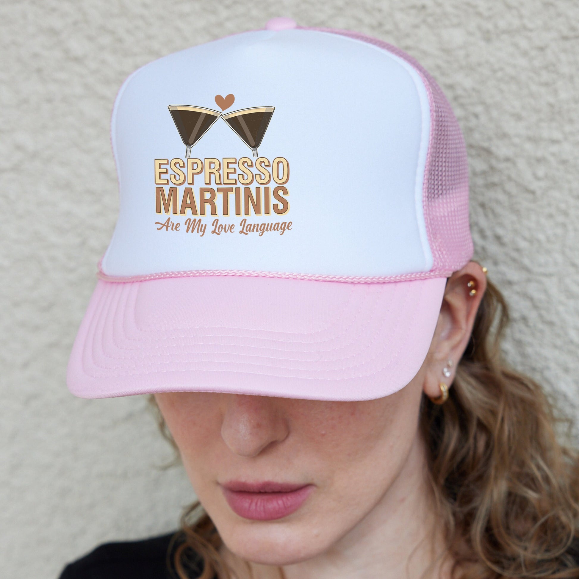 a woman wearing a pink and white trucker hat