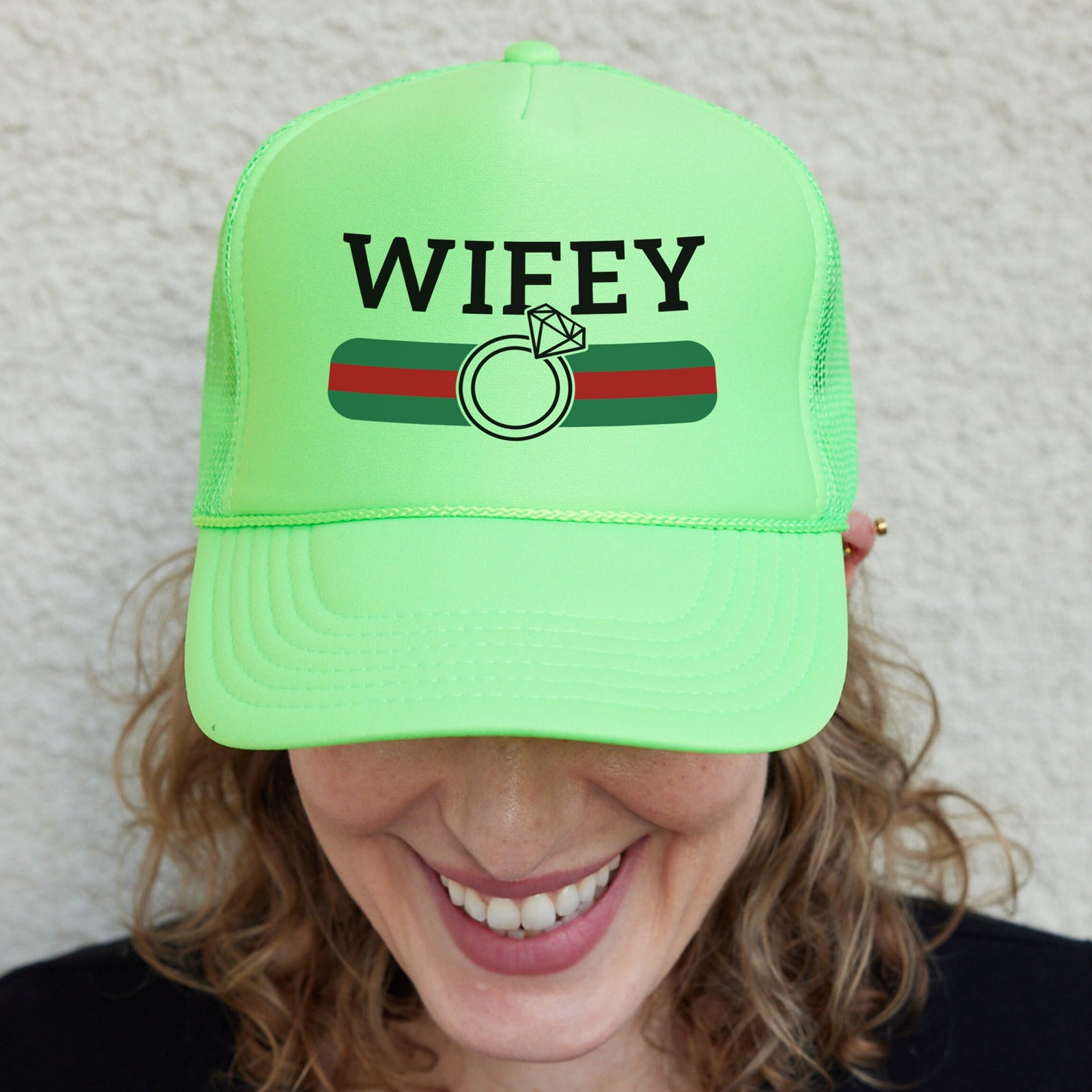 a woman wearing a green hat with the word wife on it