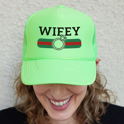 a woman wearing a green hat with the word wife on it