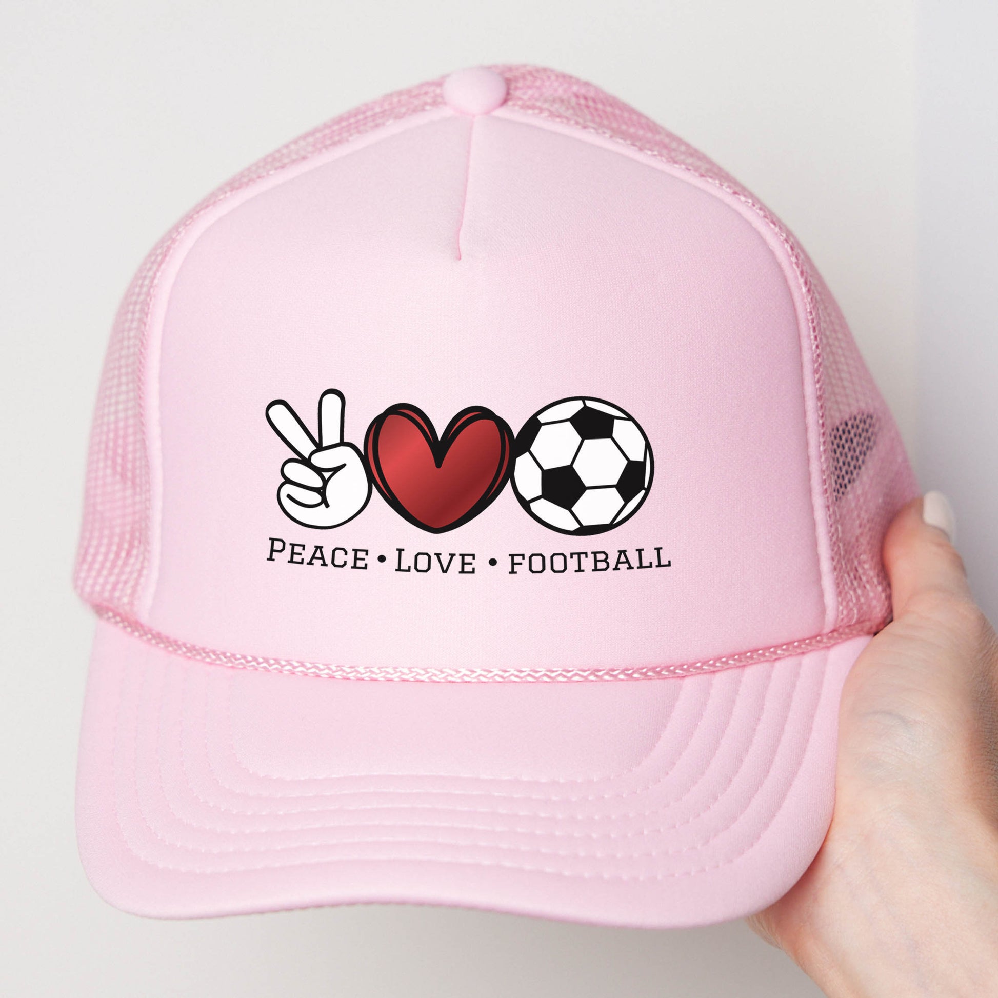 a pink trucker hat with peace love football written on it