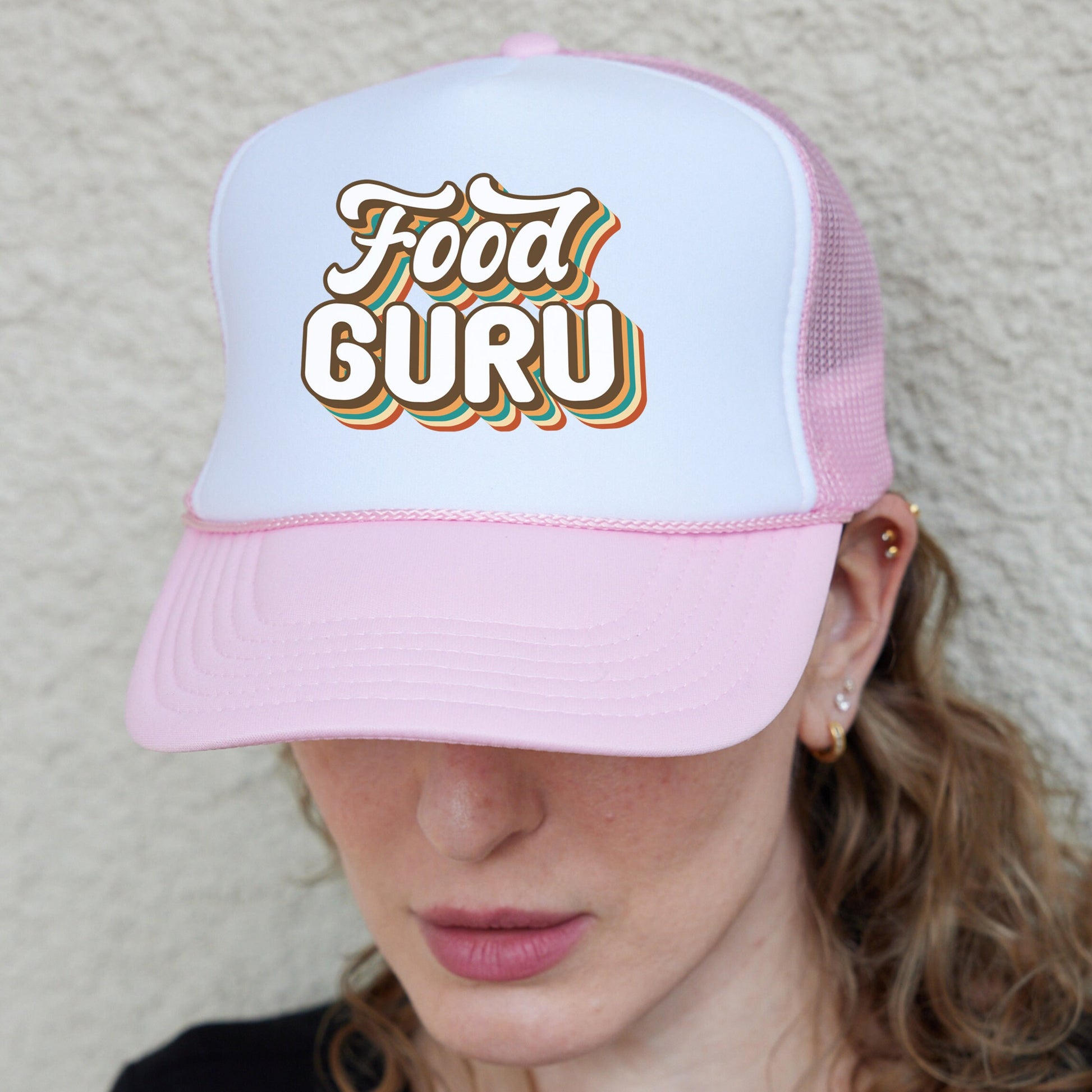 a woman wearing a pink and white trucker hat