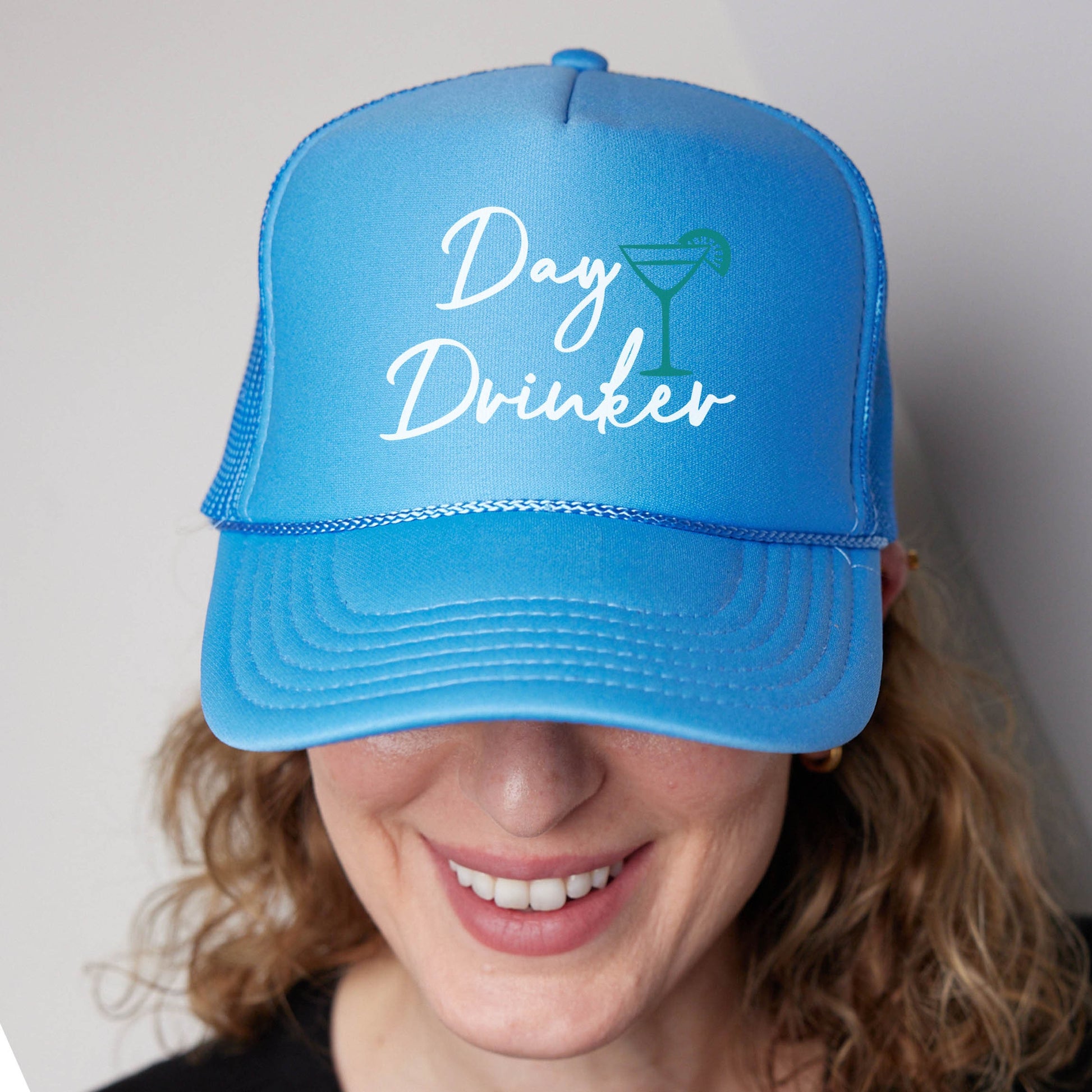 a woman wearing a blue hat that says day drinker