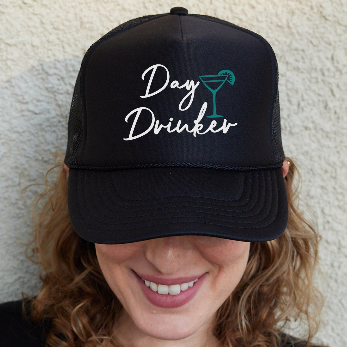 a woman wearing a black hat with the words day drinker on it
