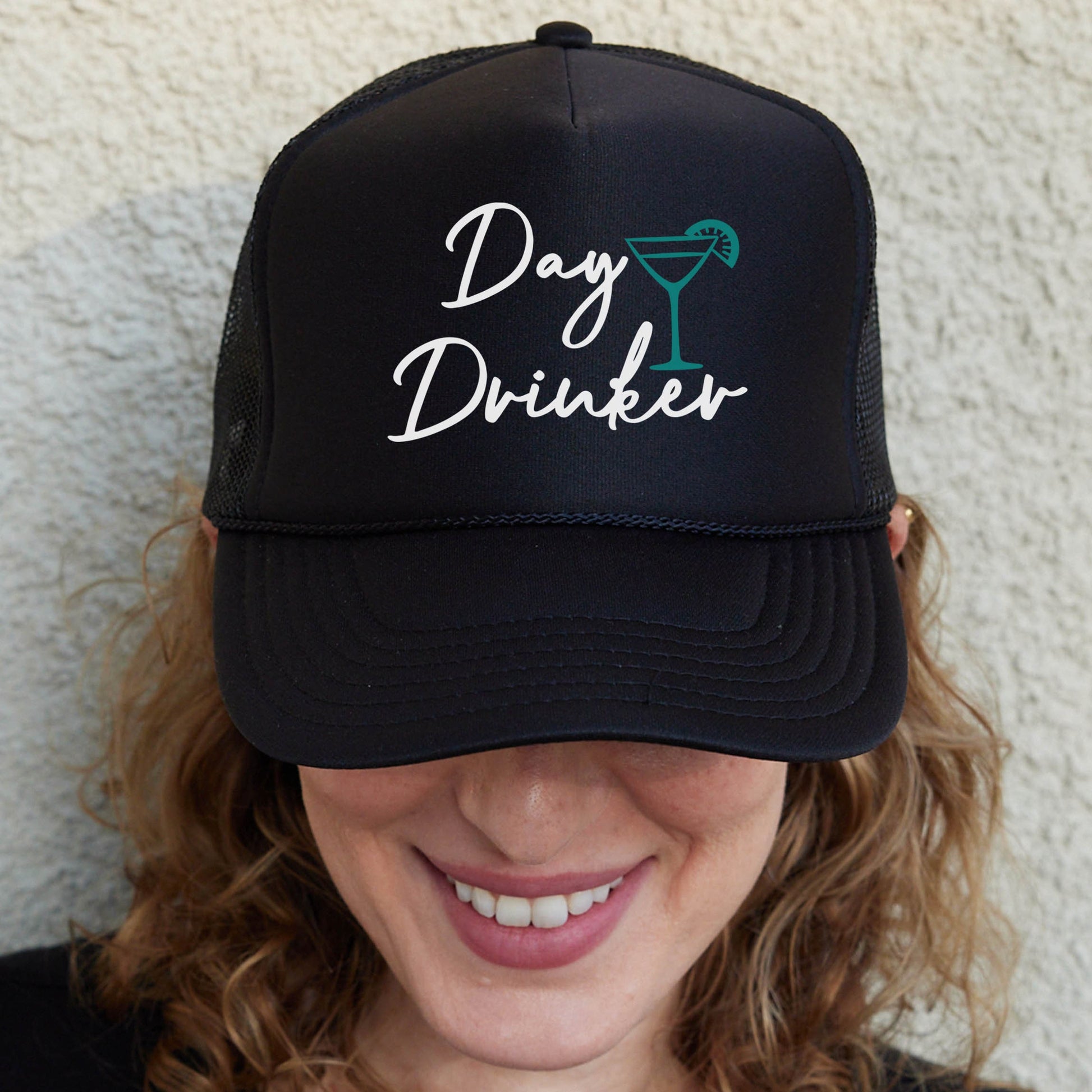 a woman wearing a black hat with the words day drinker on it