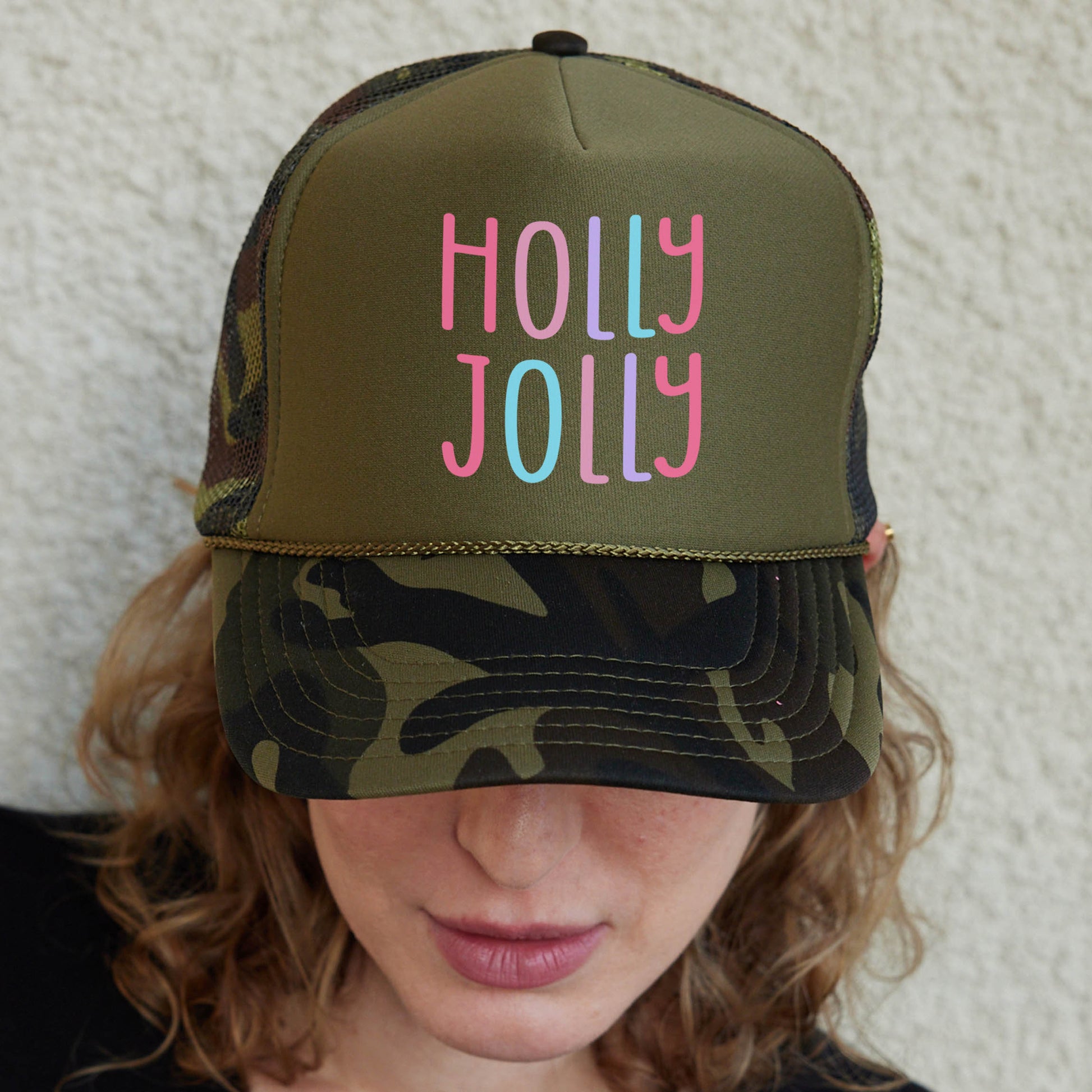 a woman wearing a hat with the words holly jolly on it
