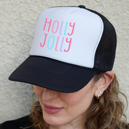 a woman wearing a black and white hat with the words holly jolly on it
