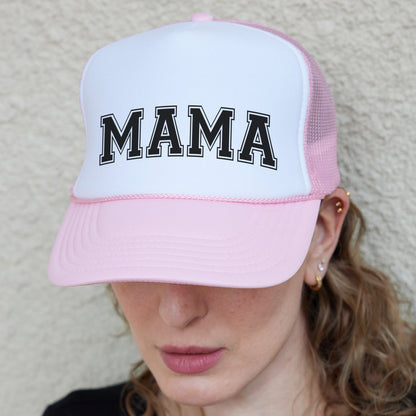a woman wearing a pink and white hat with the word mama on it