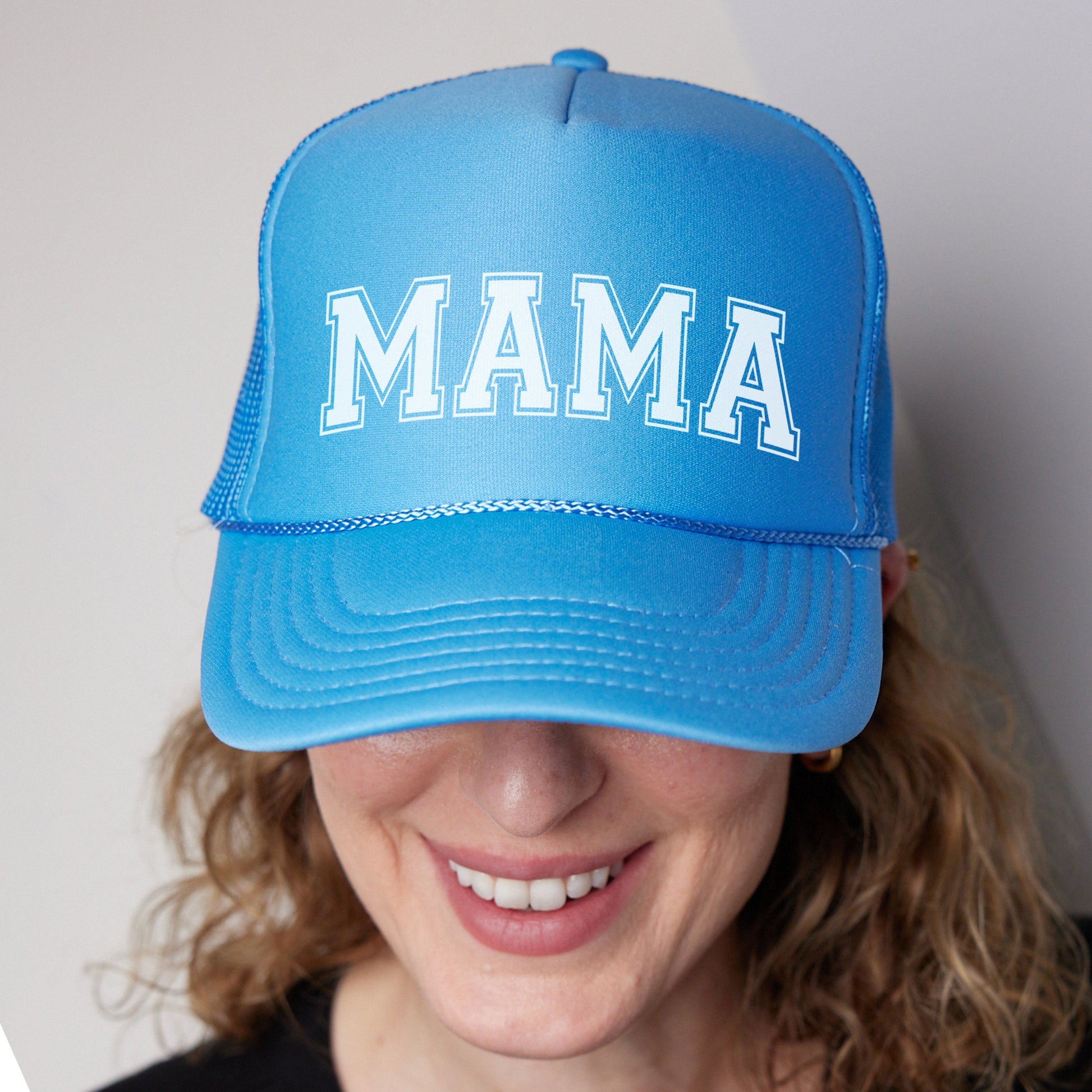 a woman wearing a blue hat with the word mama on it