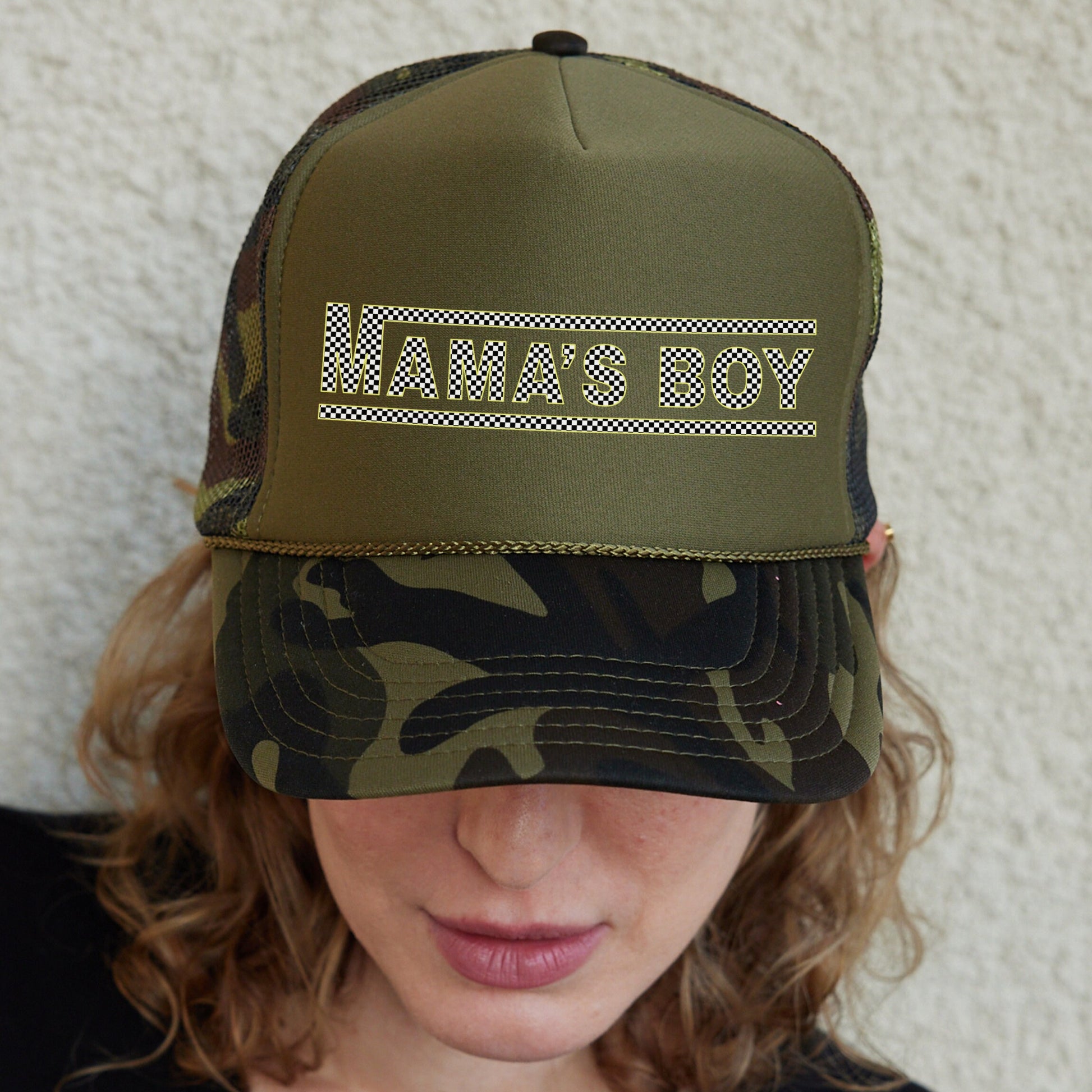 a woman wearing a camo trucker hat with the word army on it