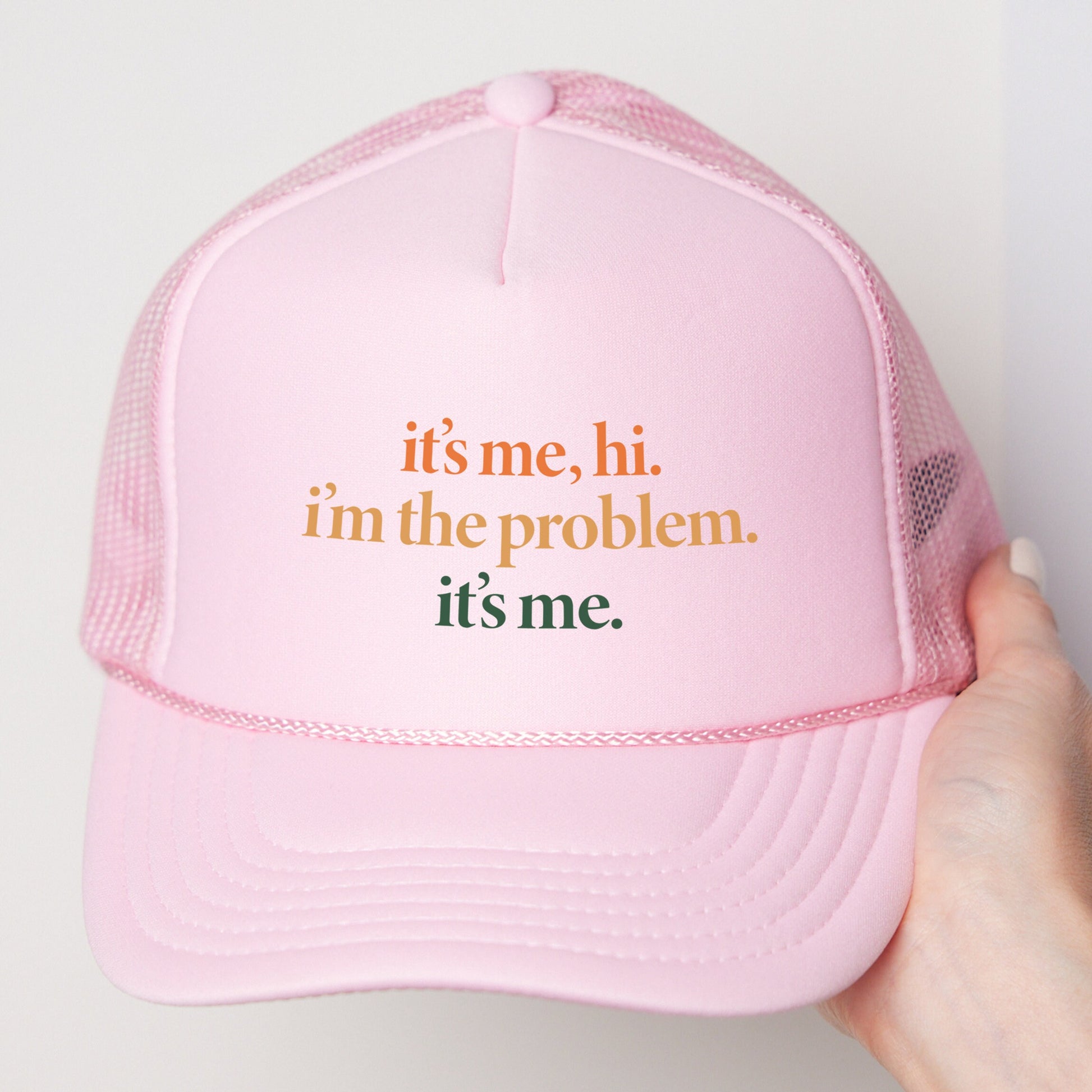 a person holding a pink trucker hat that says, it&#39;s me,