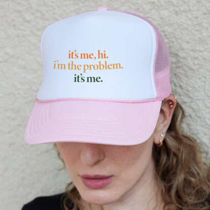 a woman wearing a pink and white hat with the words it&#39;s me,