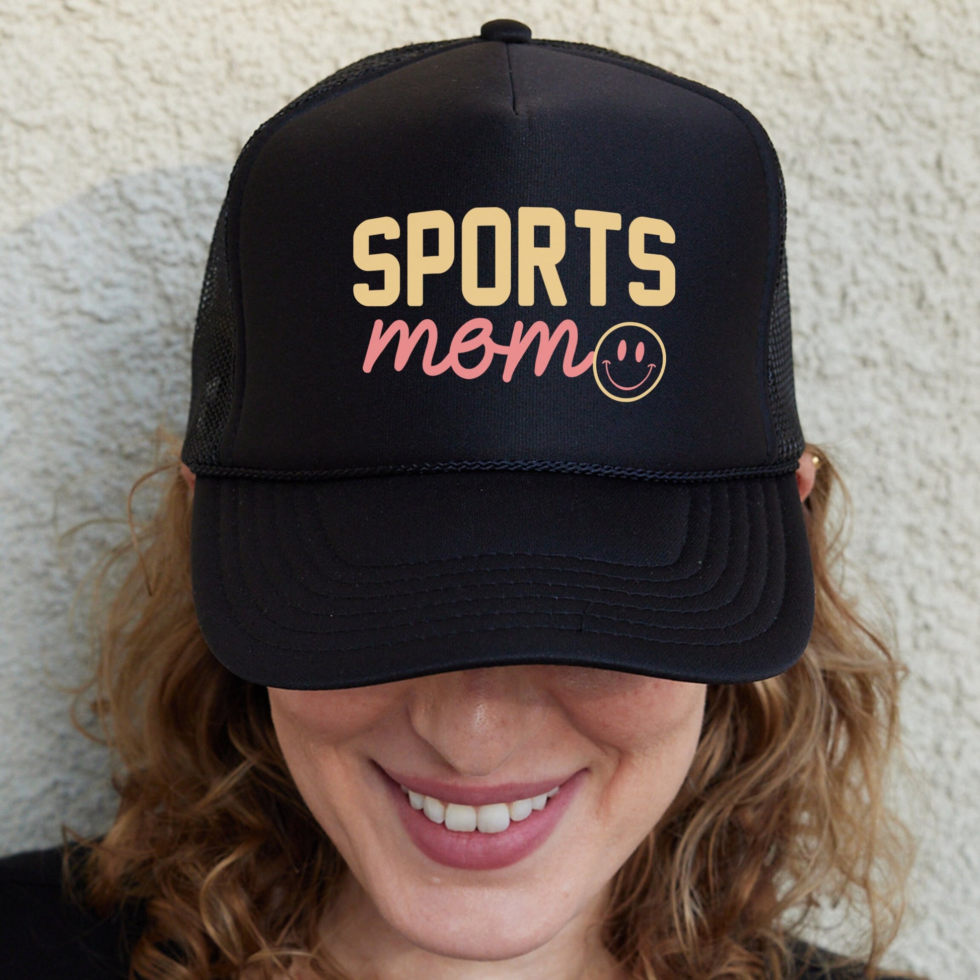 a woman wearing a black sports mom hat