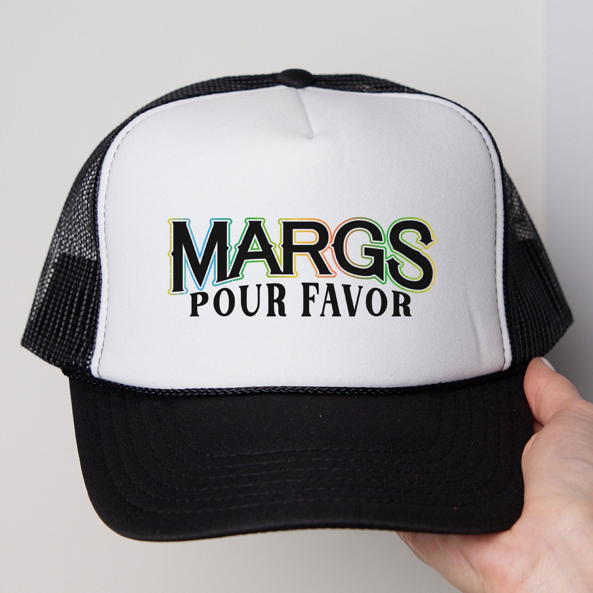 a person holding a white and black trucker hat