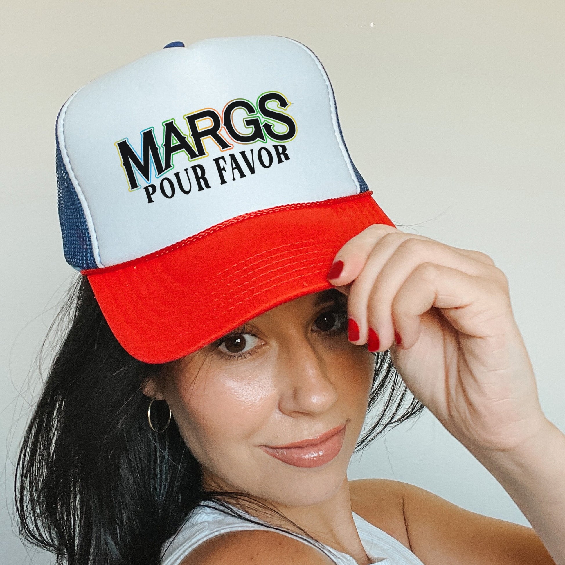 a woman in a white tank top and a red and blue trucker hat