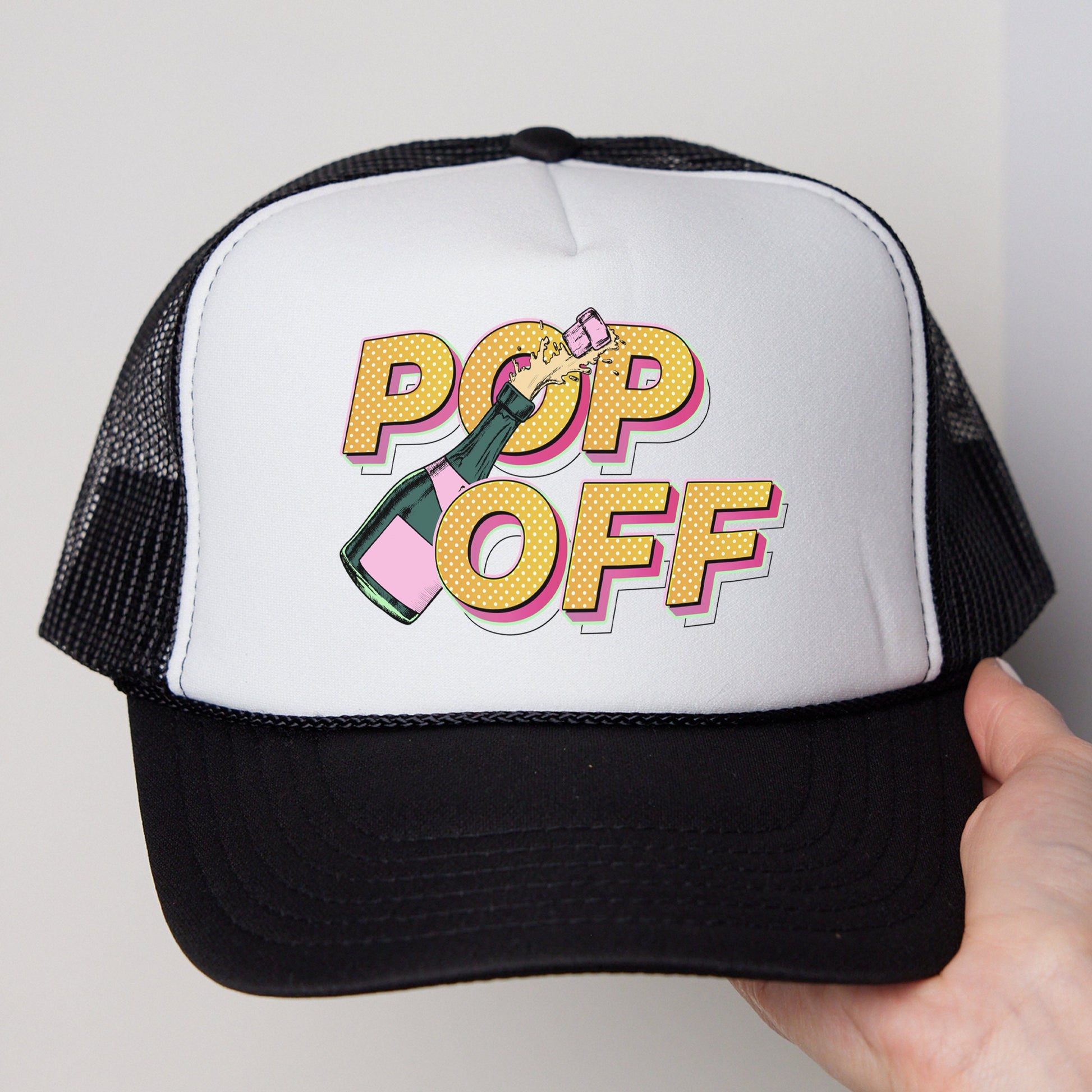 a person holding a white and black hat with pop off on it