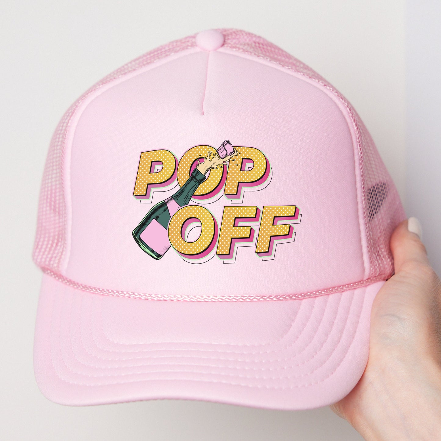 a pink hat with a pop off sticker on it